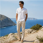 Man wearing white Belrino linen Henley shirt by Mediterranean sea cliff