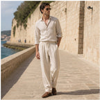 Dorevane beige trousers styled on a Mediterranean promenade