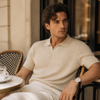Man wearing beige Elvello rib-knit polo at a European cafe