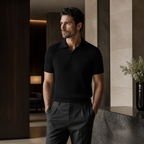 Man wearing black Elvello rib-knit polo in a refined interior