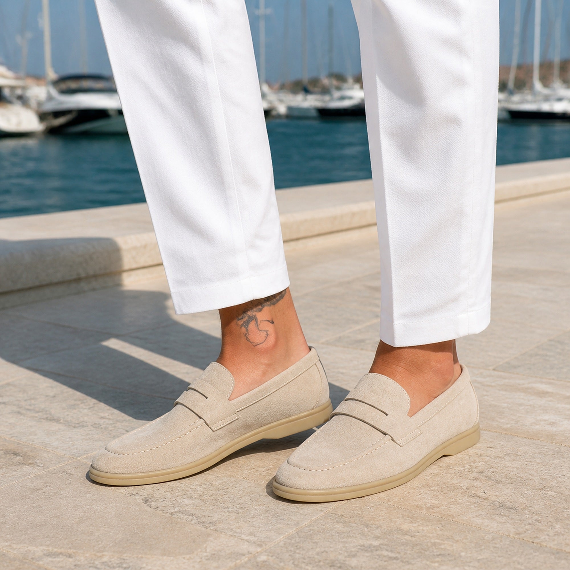 Man wearing Cormont beige penny loafers at a marina