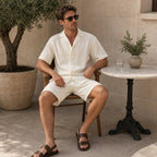 Man seated in the Belvento ivory textured set at a terrace cafe