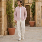 Urerino men's light pink shirt and off-white trousers in a Mediterranean courtyard