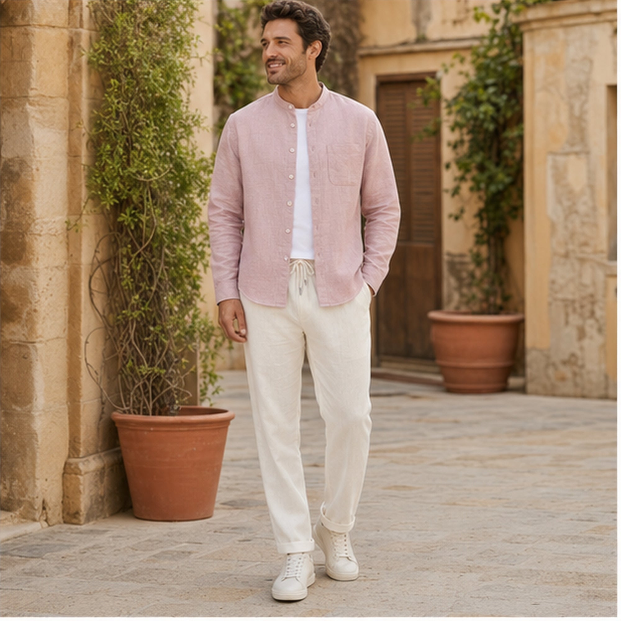Urerino men's light pink shirt and off-white trousers in a Mediterranean courtyard