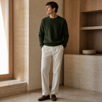Man wearing the green Urevento sweater in a refined villa interior