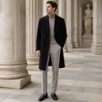 Man wearing the black Wynrel overcoat in a European colonnade