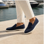 Navy Zalemora suede loafers styled beside a Mediterranean marina