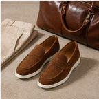 Brown Zalemora suede loafers in a refined travel still life